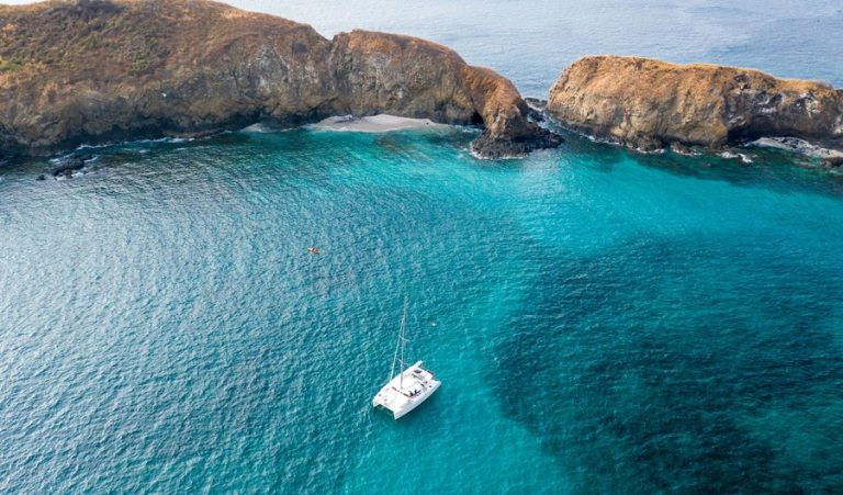 Catamarán navegando en aguas turquesa de la costa de Guanacaste
